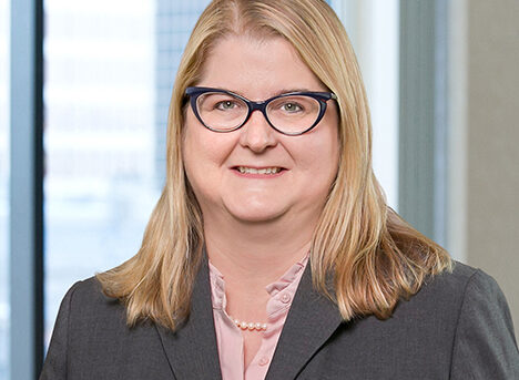 A professional headshot of Kathryn Windsor in front of windows.